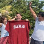 student with a Harvard college t-shirt and two people celebrating